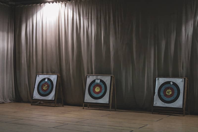three archery target in front of a curtain