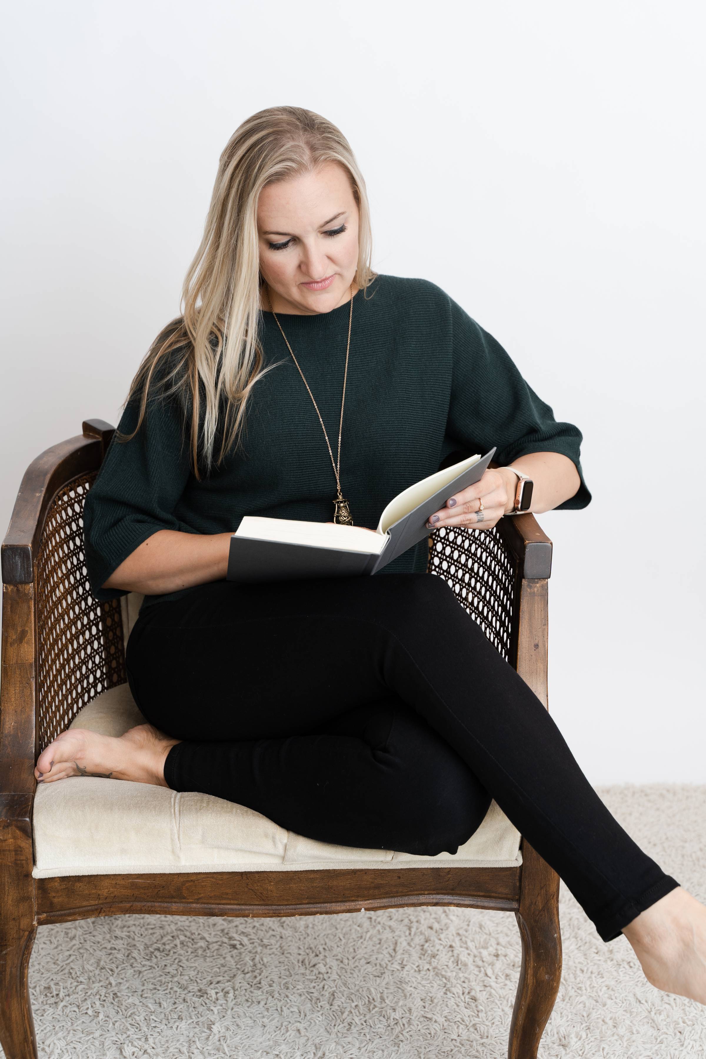 Erin sitting in a chair reading a book