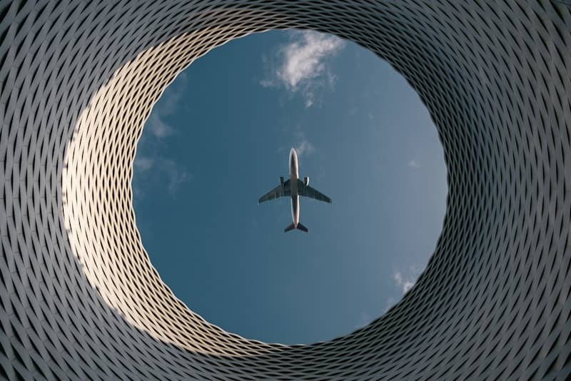An airplane flies through a circular opening.
