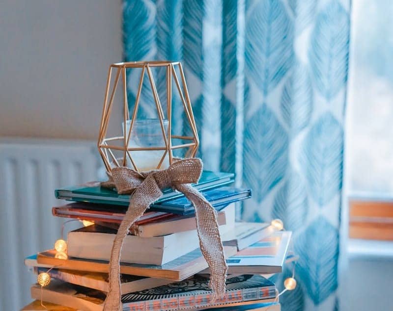 brown wooden framed candle holder on top of books