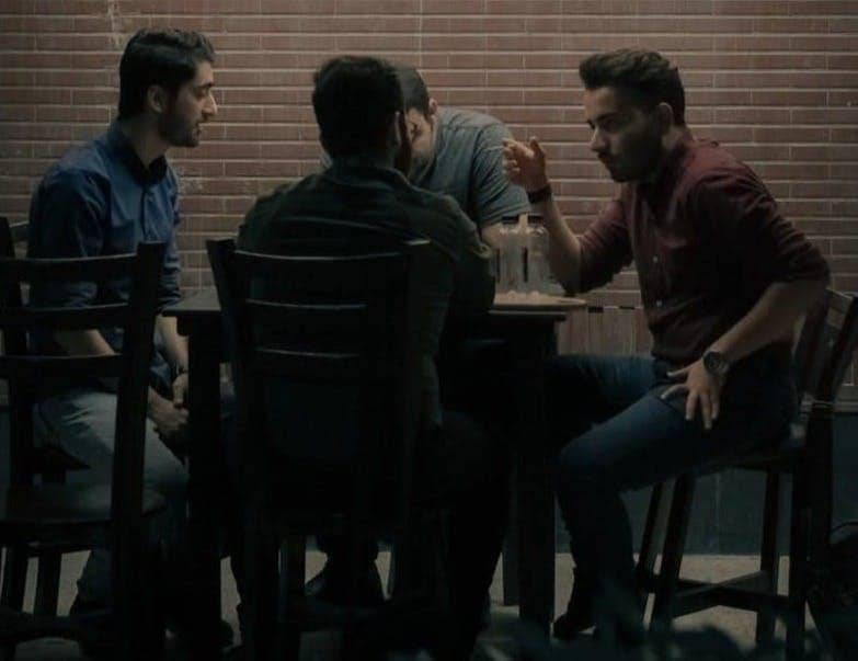 four men sitting beside table