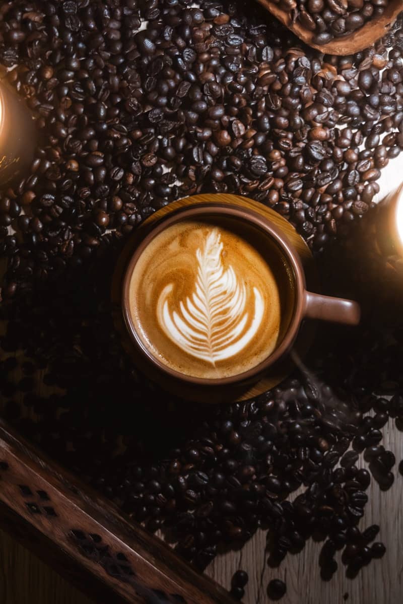 A cup of coffee with a leaf on top of it
