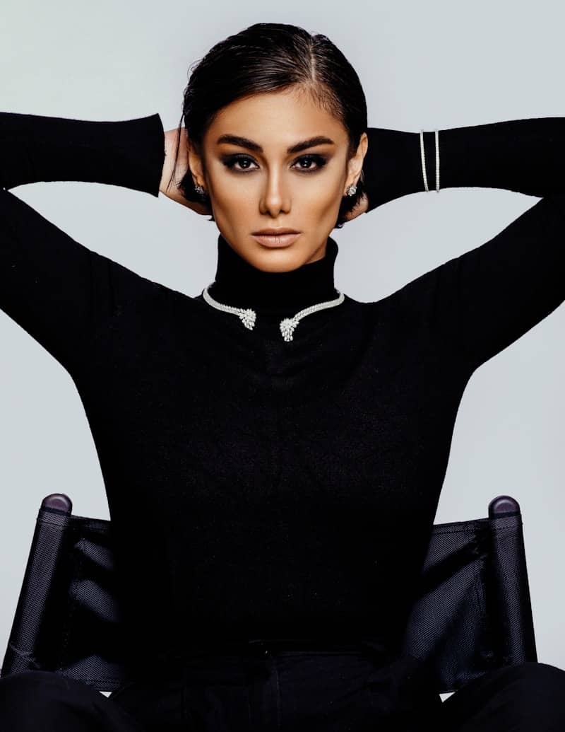 A woman sitting in a chair with her hands on her head
