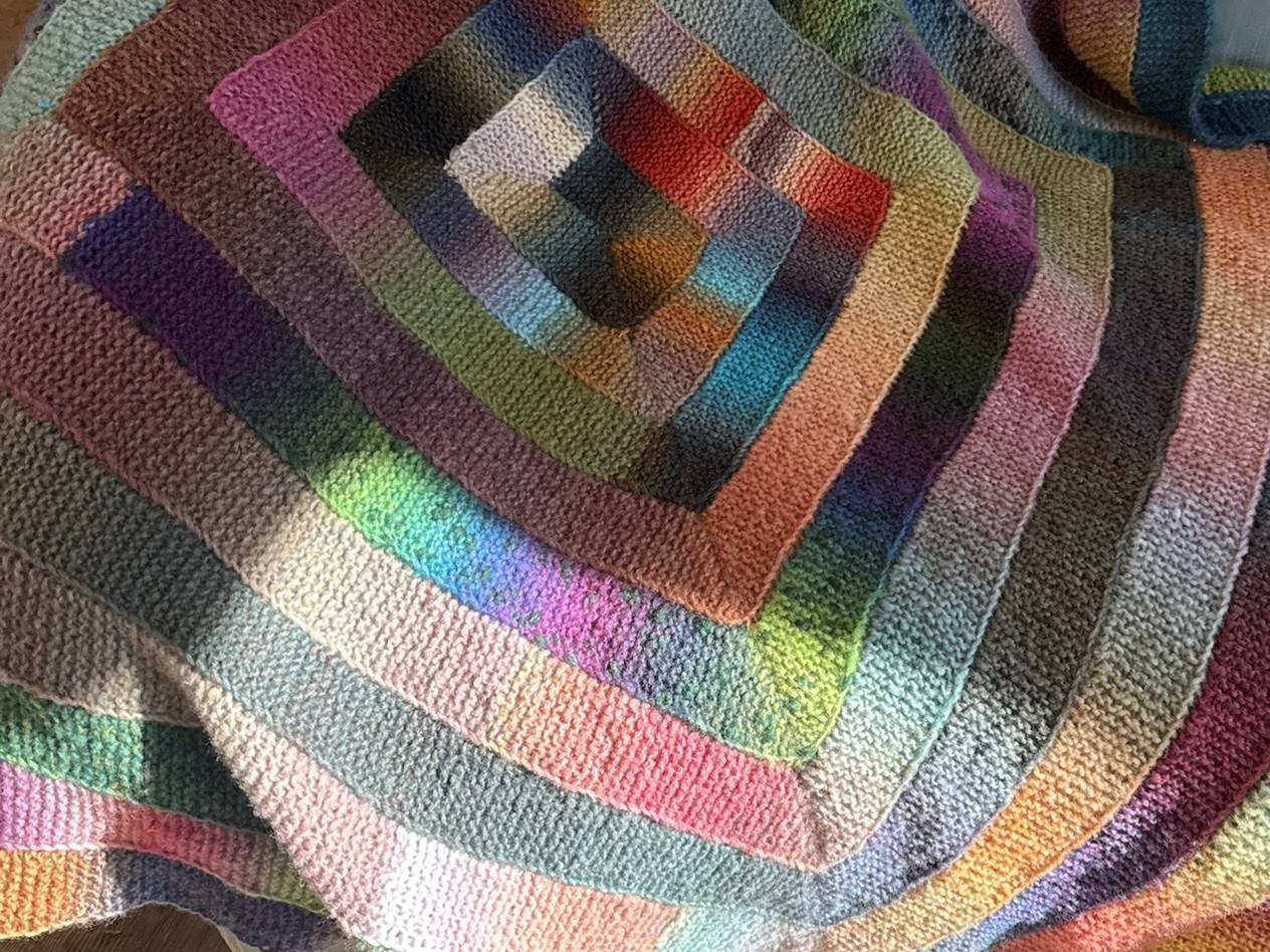 A ten-stitch garter stitch blanket in alternating light and dark colors