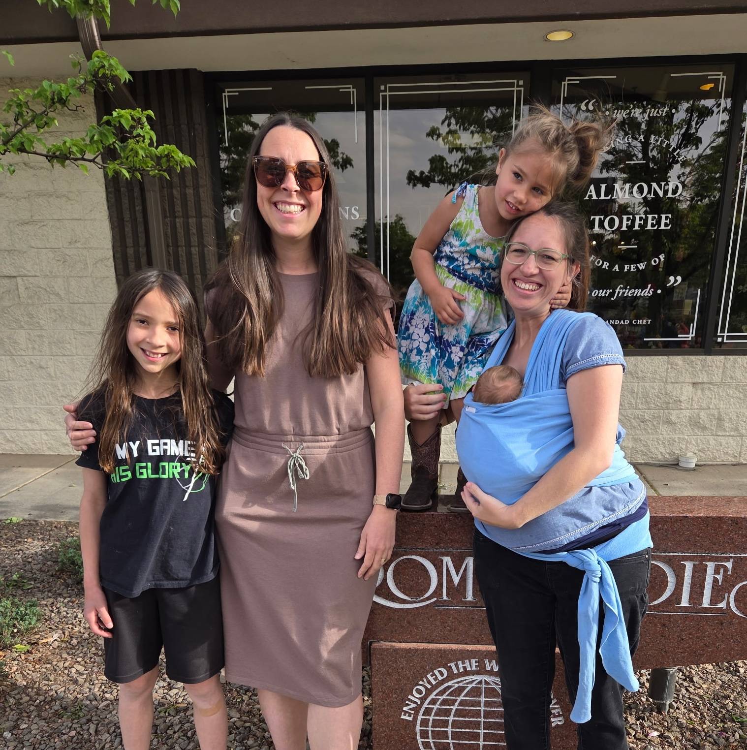 Me and my friend Rachel standing outside a coffee shop with our children, smiling together.