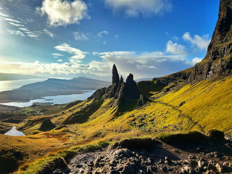 Dramatic rock formations on a grassy hillside overlooking a loch