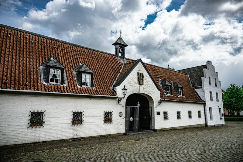 Historic white building with a red tiled roof and archway