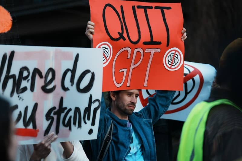 Man holds sign that says quit gpt.