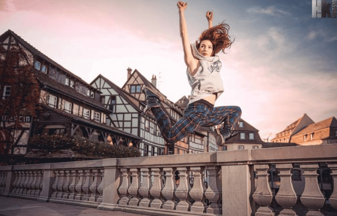 marlo wearing the tartan flow pants jumping on a bridge in Fran