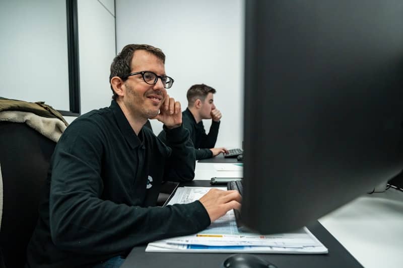 A man works at a computer in an office.