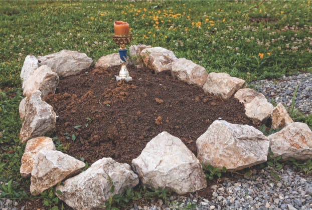 Freshly dug gravesite with stone border