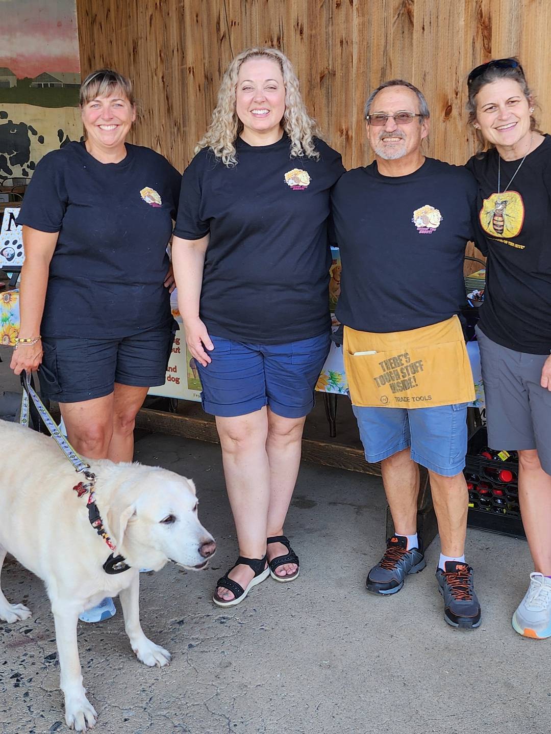 four people standing behind a dog