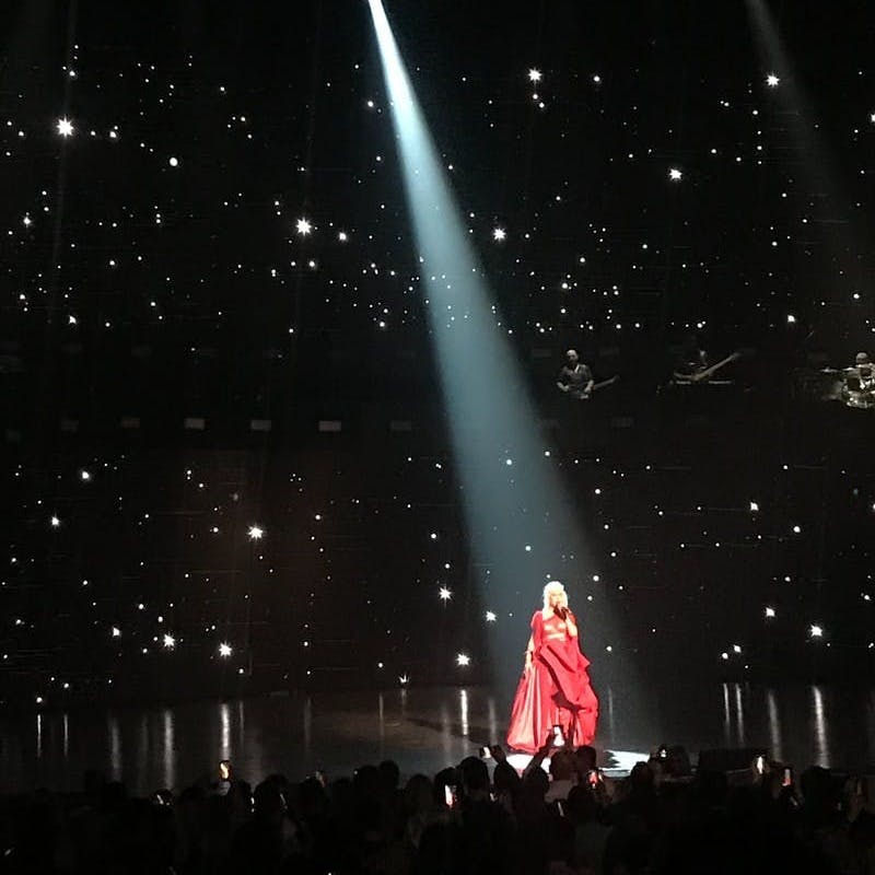 woman wearing red dress performing stage