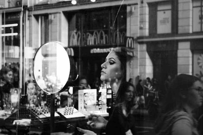 woman in black long sleeve shirt standing near glass window