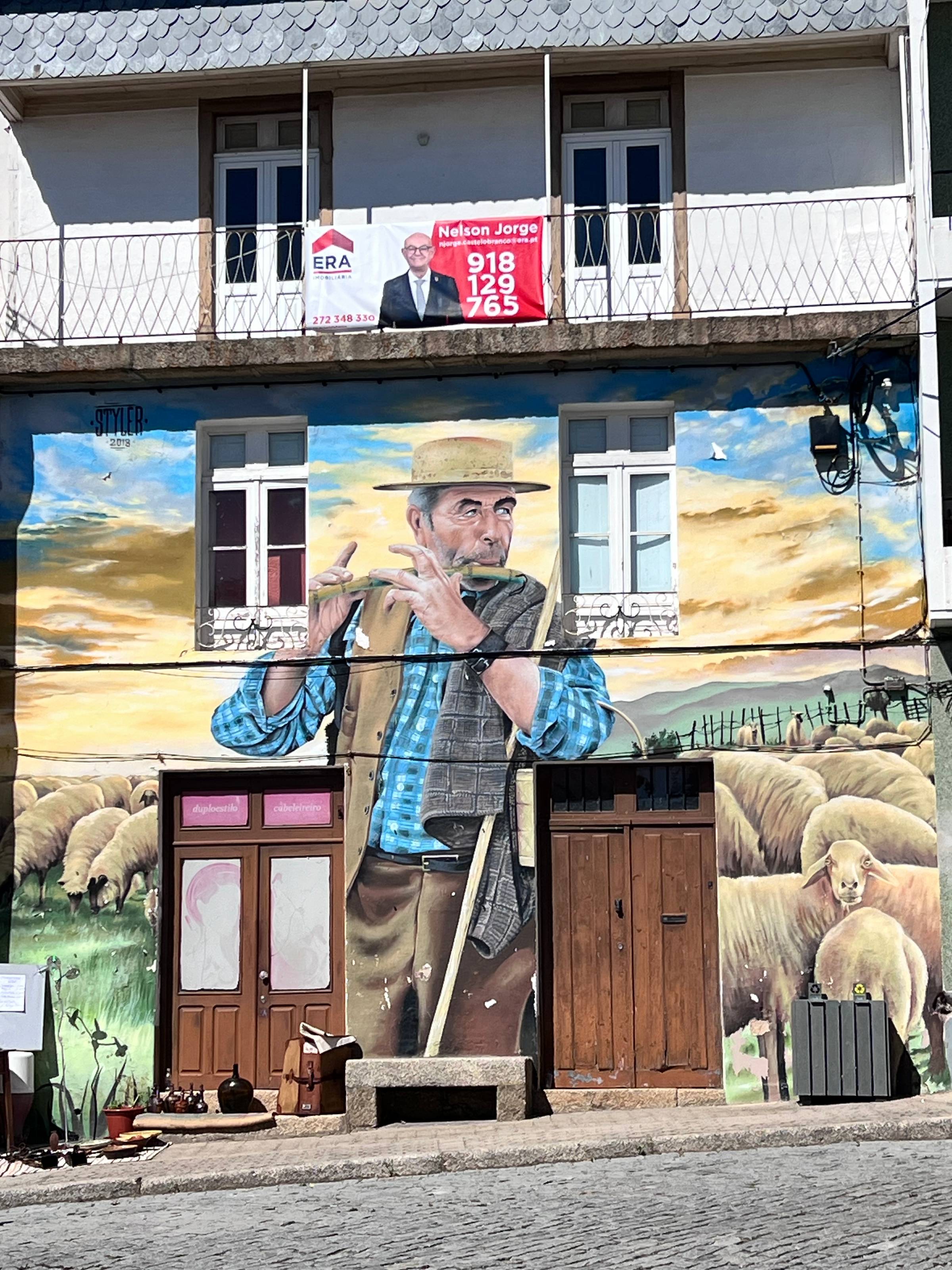 colourful mural of Portuguese shepherd and sheep painted on house