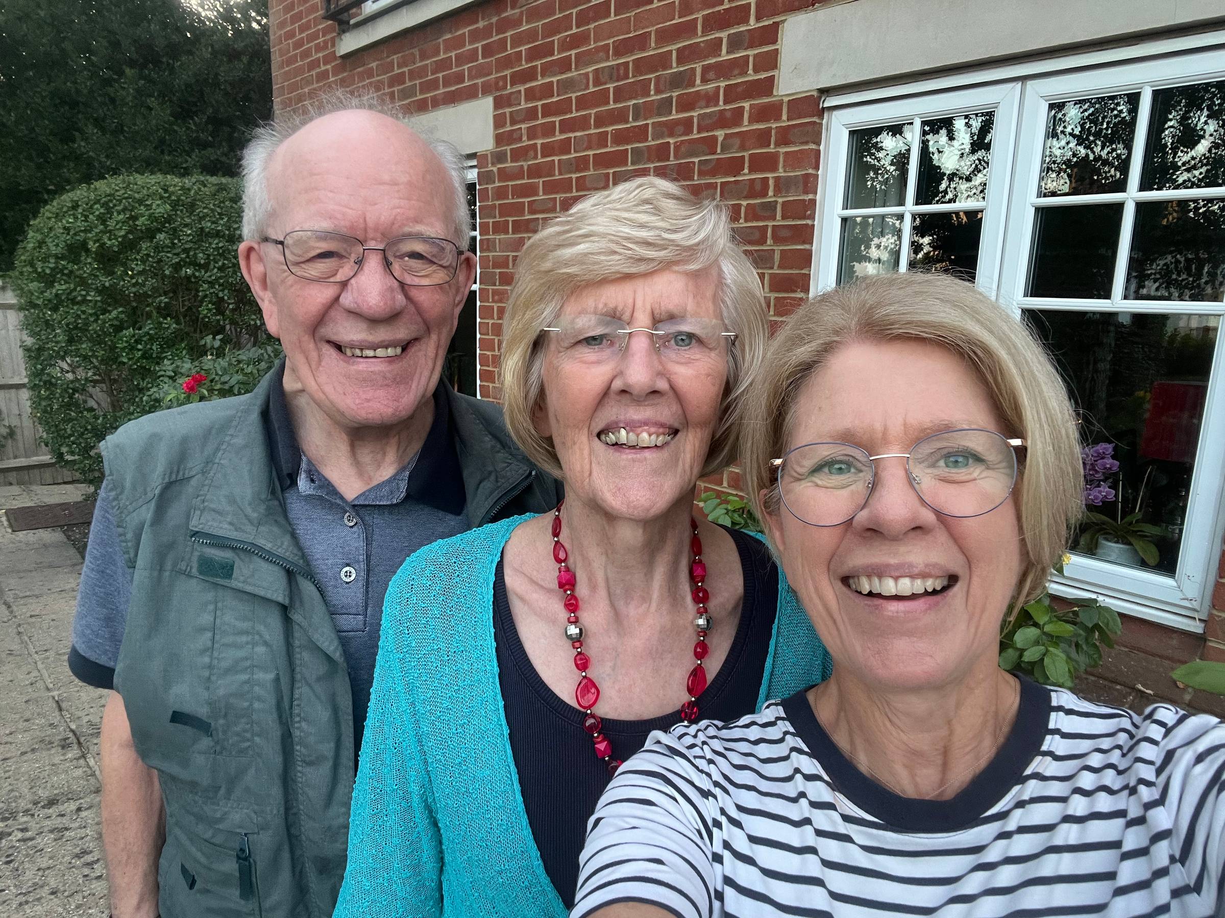 3 people smiling, a man, woman and daughter
