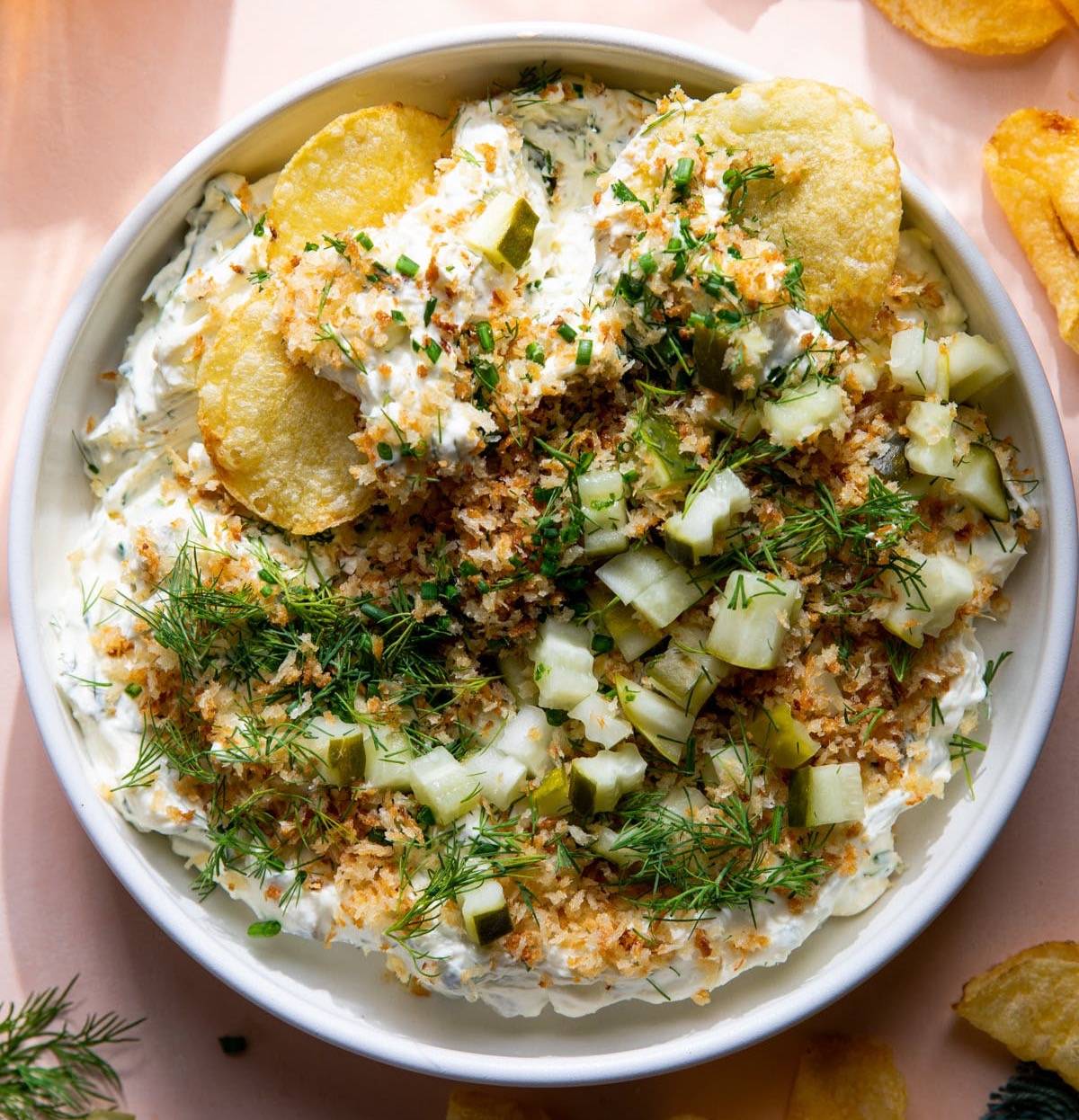 Fried pickle and ranch dip in a bowl with potato chips.