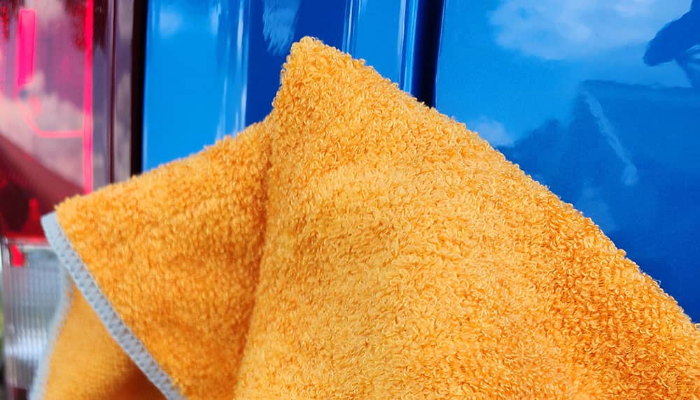 Orange micro fiber towel on a royal blue truck fender and bright red tailight 