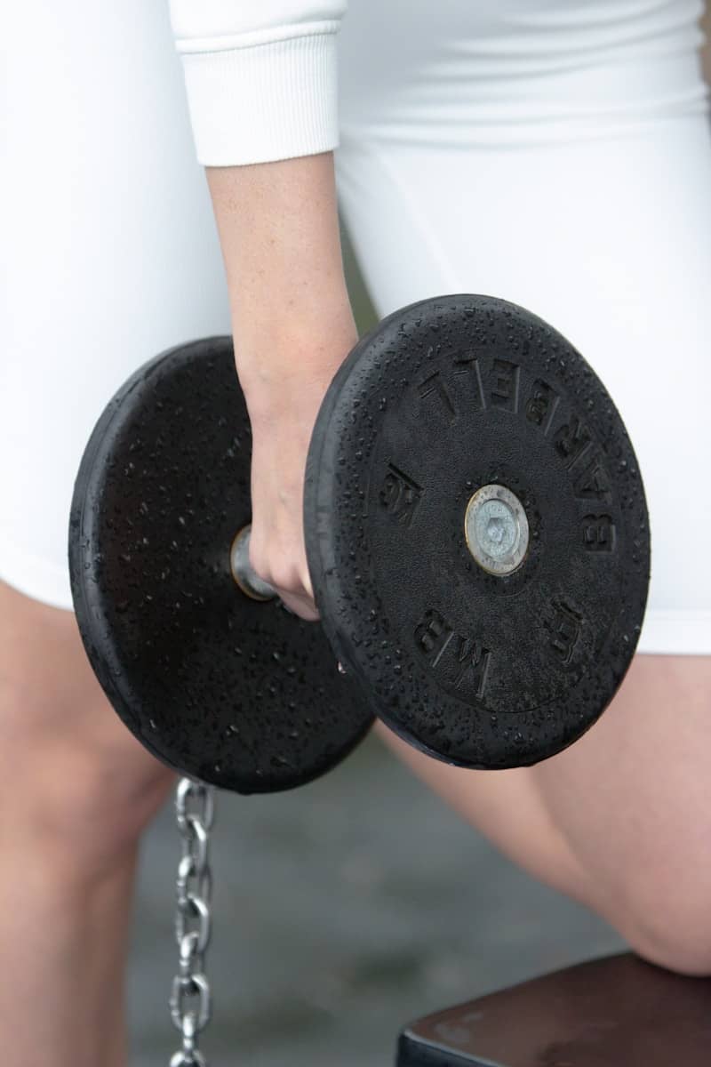 A person is holding a dumbbell during a workout.