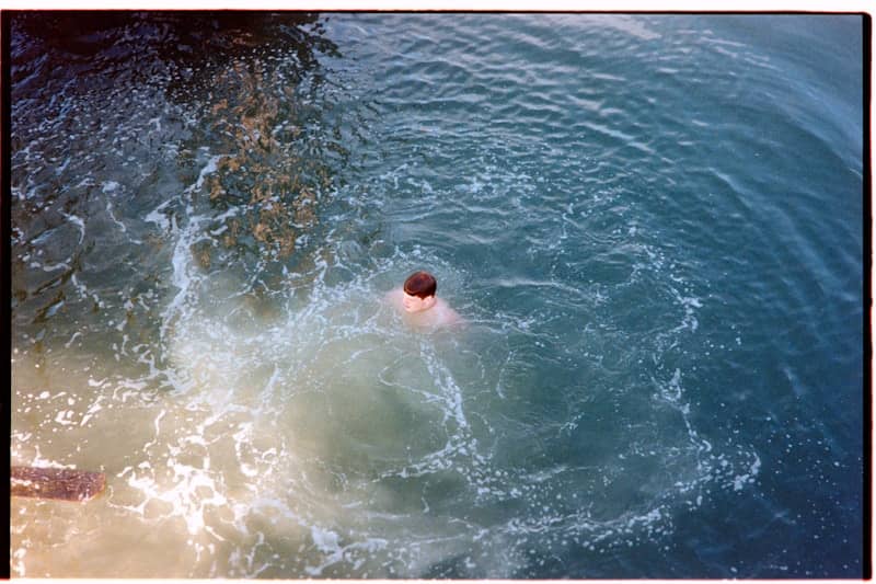 Person creating a large splash in blue water.