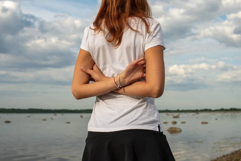 Woman with arms crossed by the water