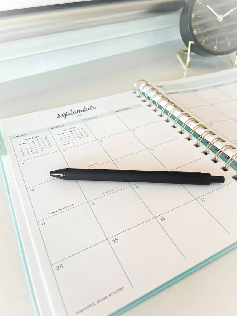A black pen rests on an open september calendar