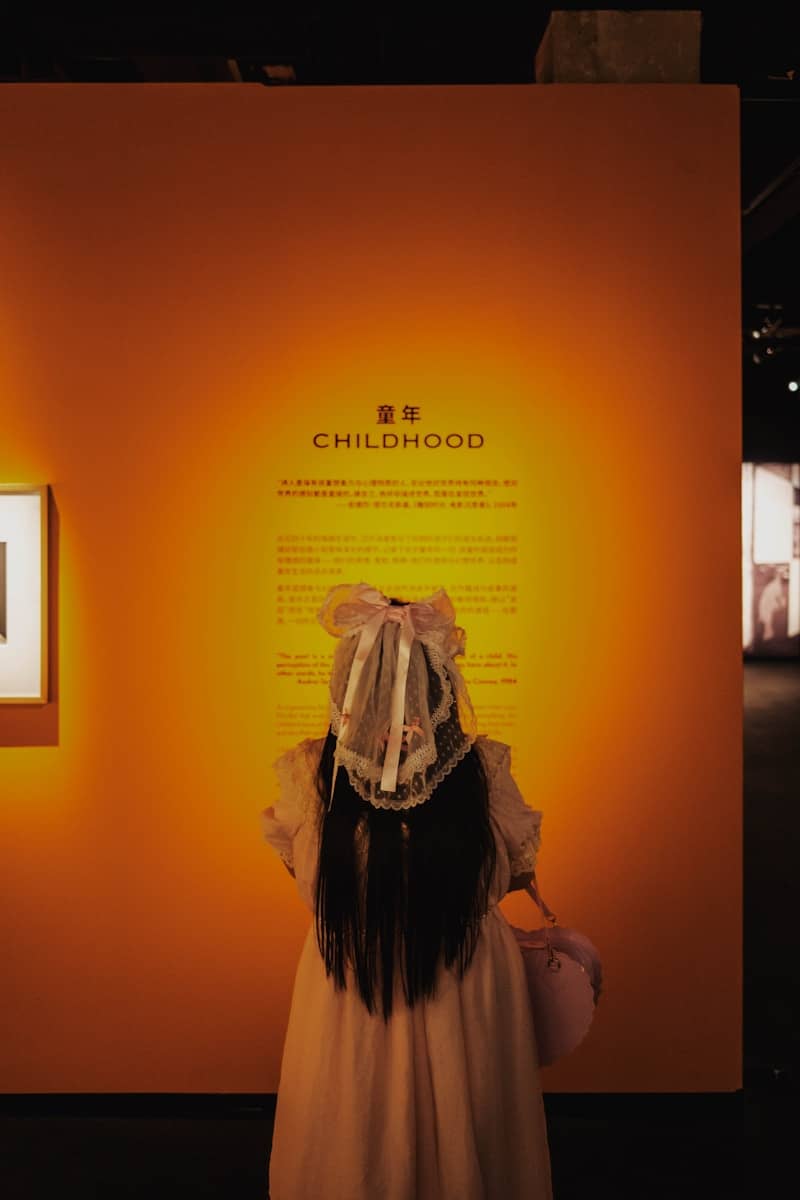 Child in a white dress reads 'childhood' display text.