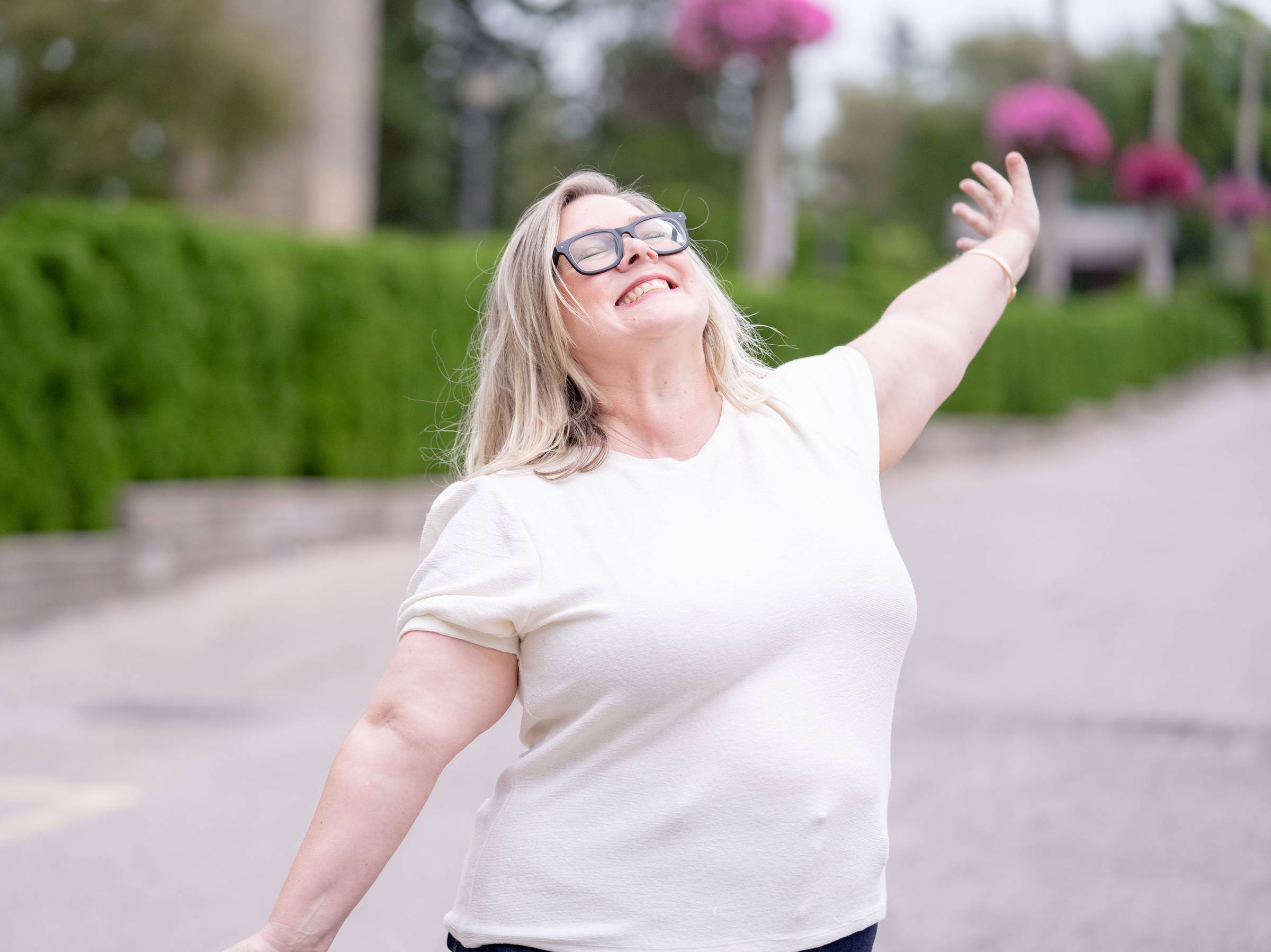 Holly Darling outside with her arms open wide.