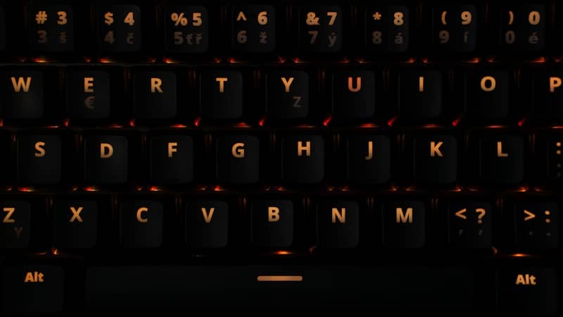 A close up of a black keyboard with a red light