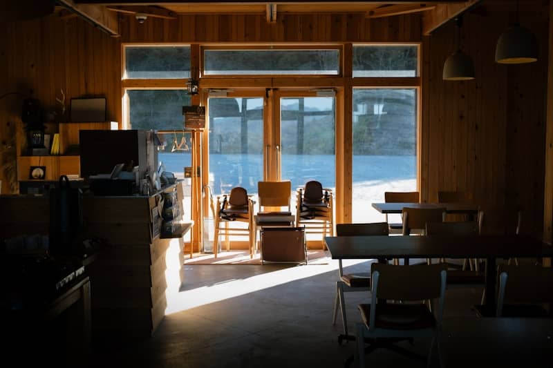 Interior of a rustic cafe with large windows overlooking water