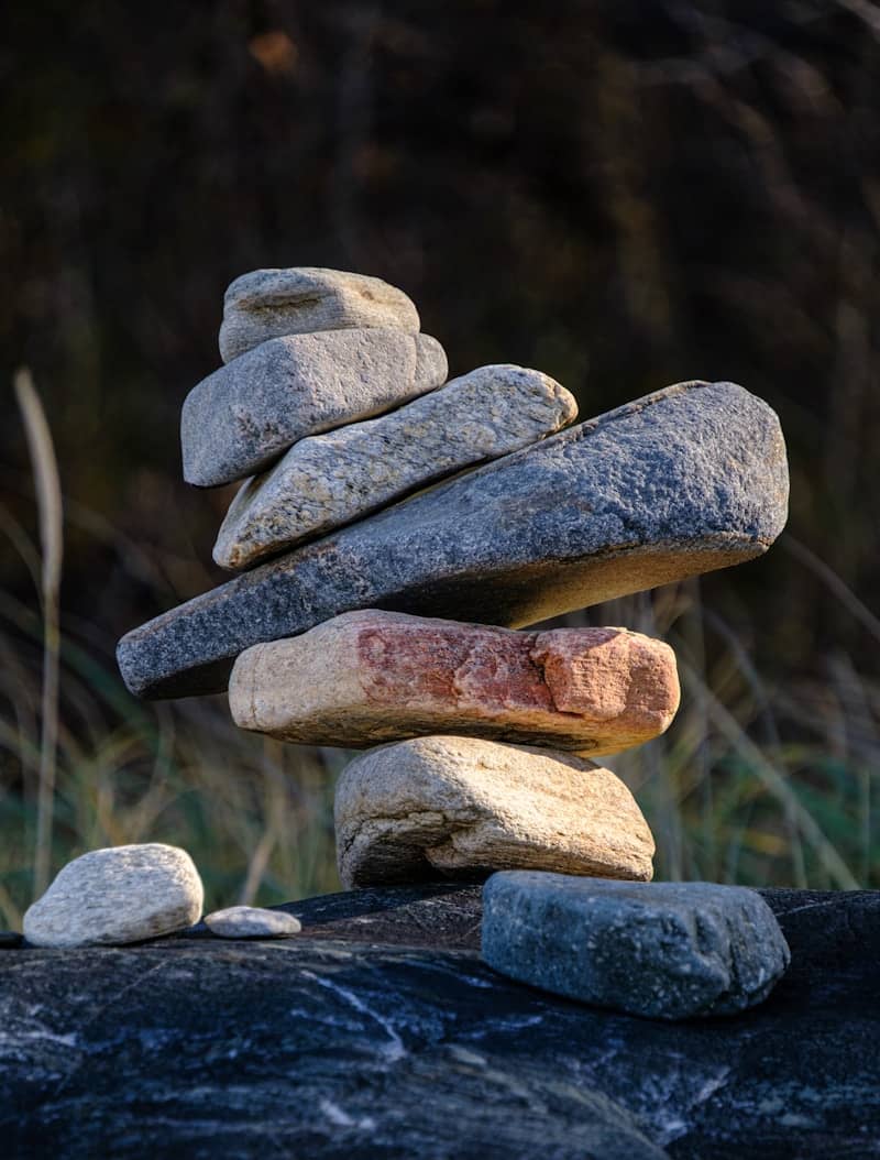 Stack of balanced stones on a dark rock.