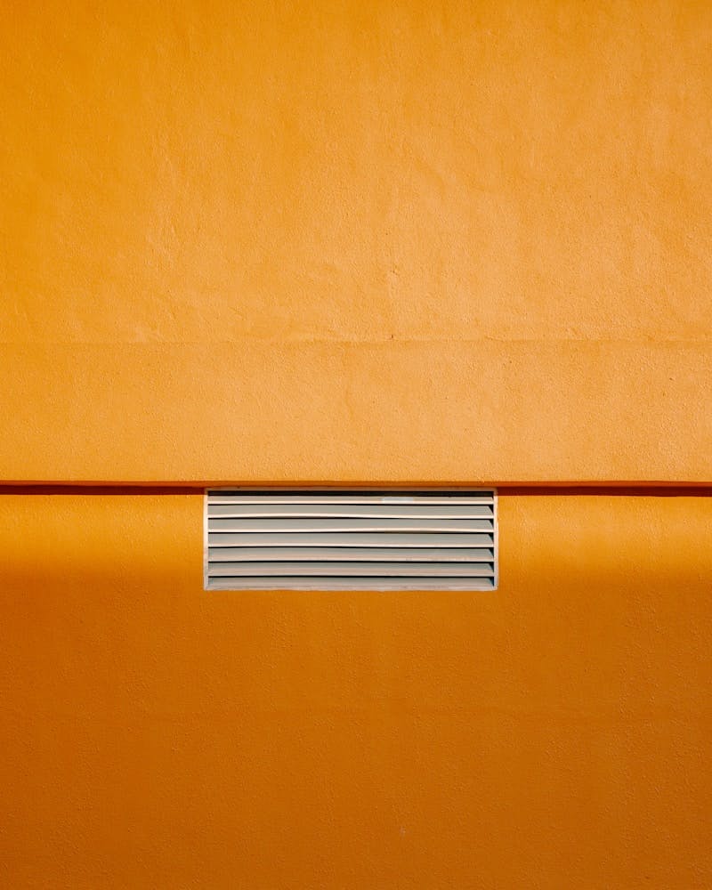 A close up of a yellow couch with a heater on top of it