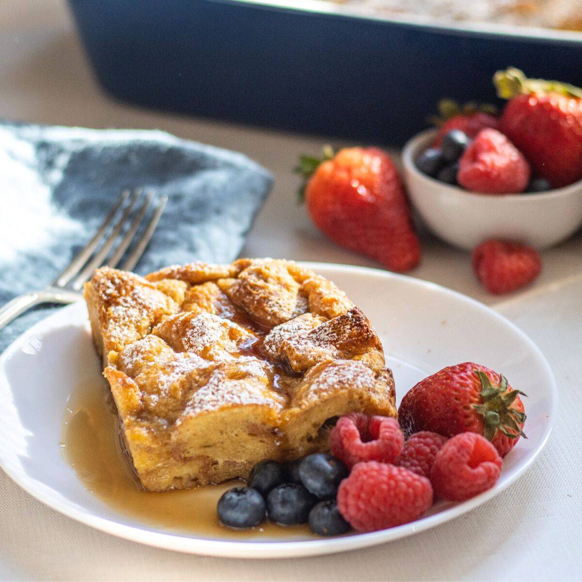 Slice of french toast casserole on a plate with berries.