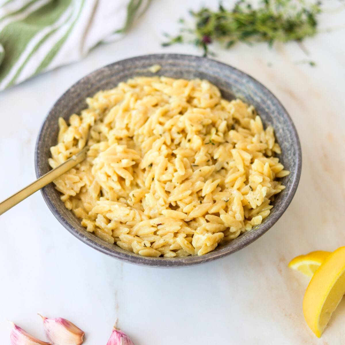 Bowl of creamy lemon orzo with a spoon.