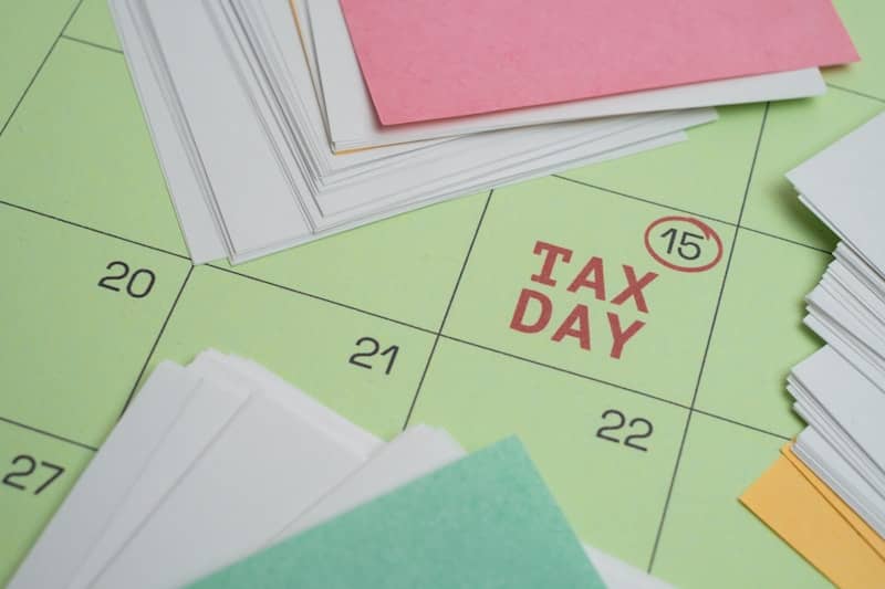 Tax day marked on a calendar with papers.