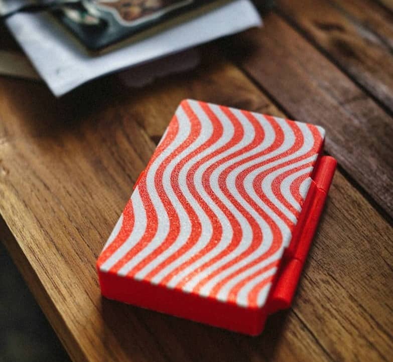 Red and white patterned notebook on a wooden table.