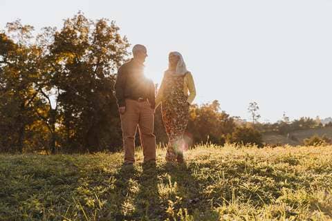 Lane and Jules walking in a sunlit field at Sweet BombDiggity Farms