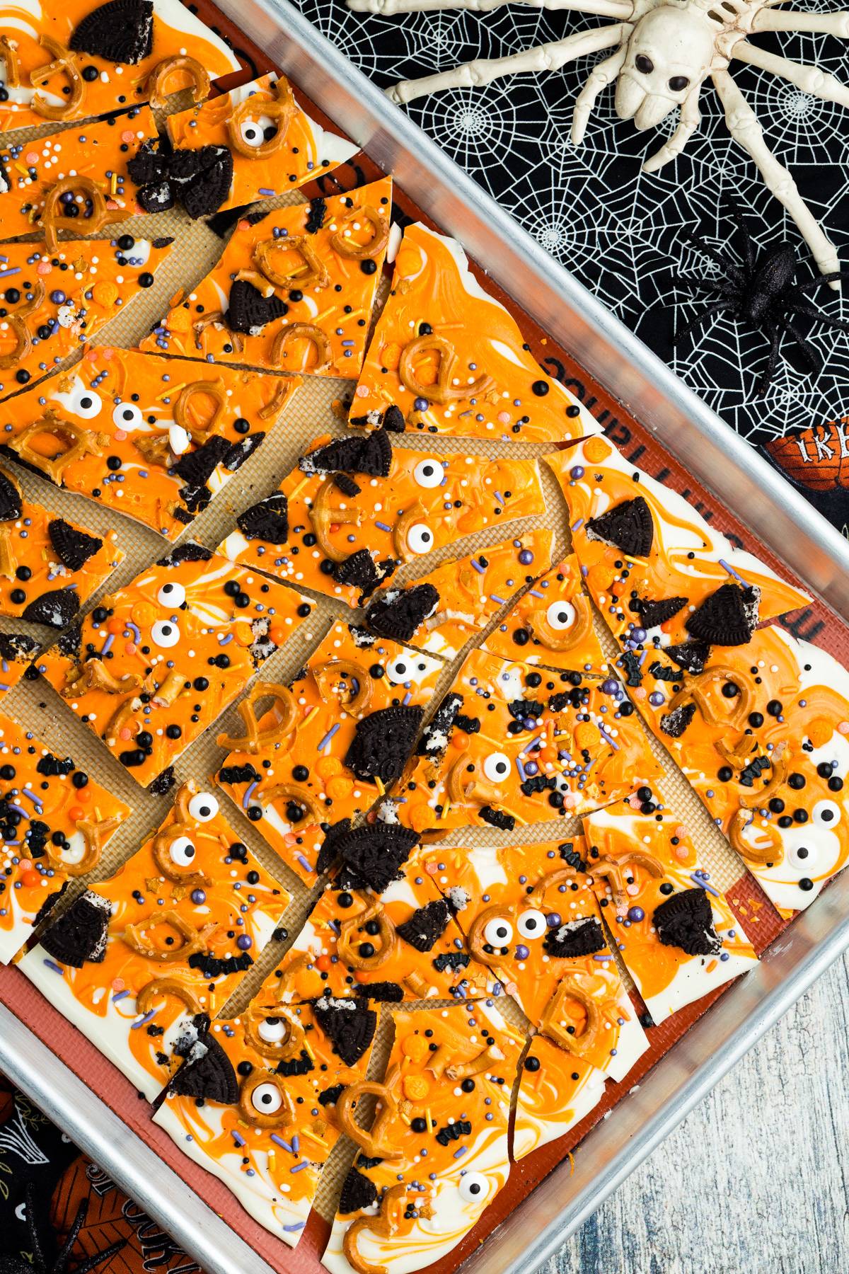 Halloween bark broken up on a sheet pan.