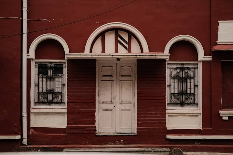A red building with white door and windows.