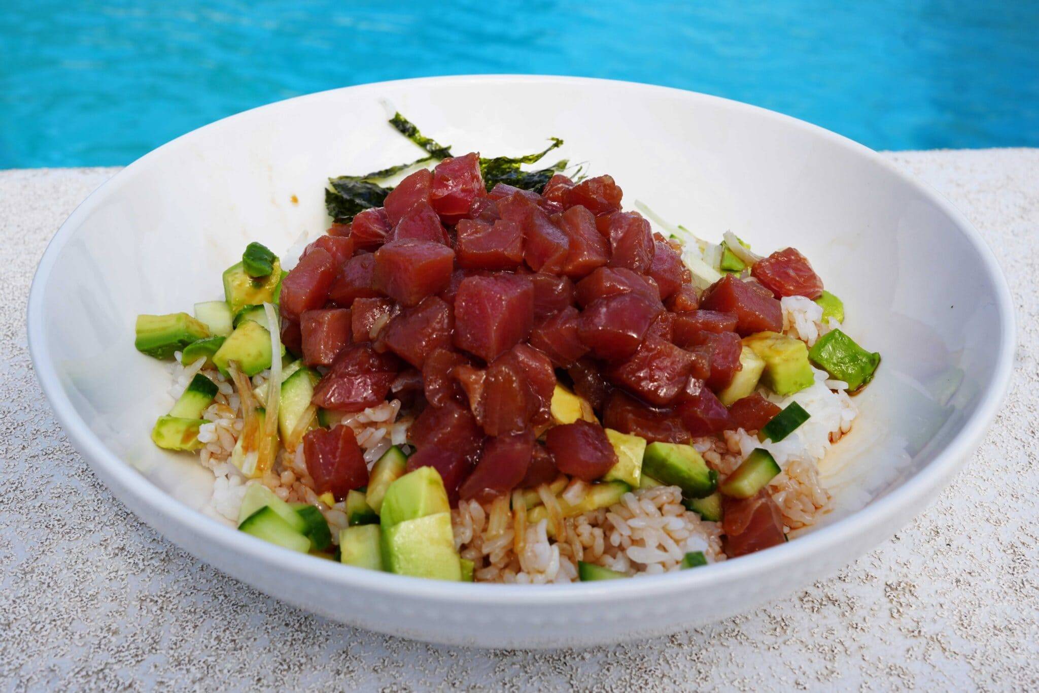 A poke bowl with fresh diced tuna, cucumber, sesame seeds served over rice. 