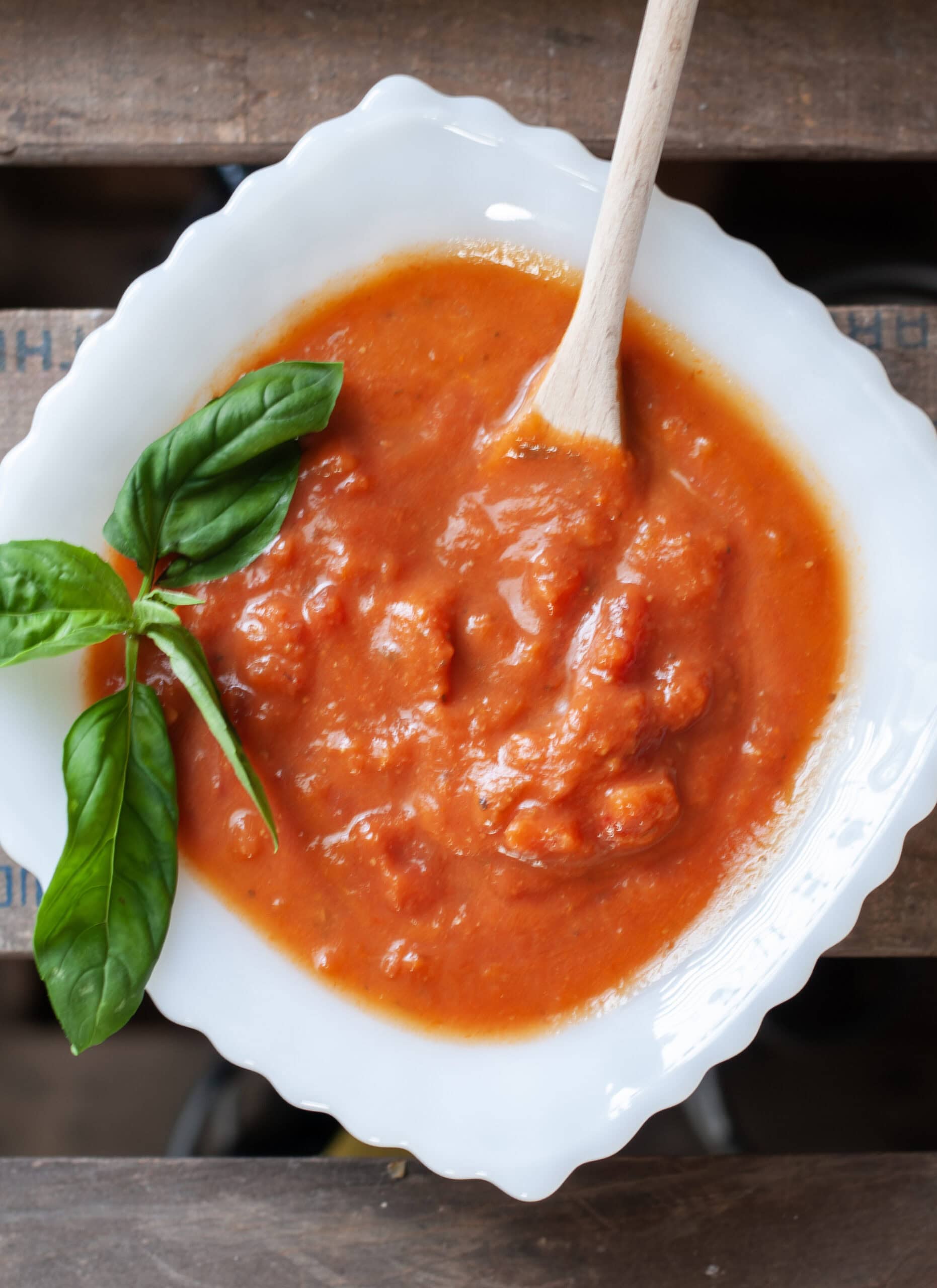 A bowl of tomato sauce with fresh basil. 