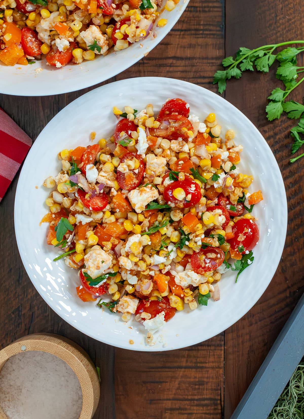 A top view of roasted corn salad with tomatoes and feta cheese. 