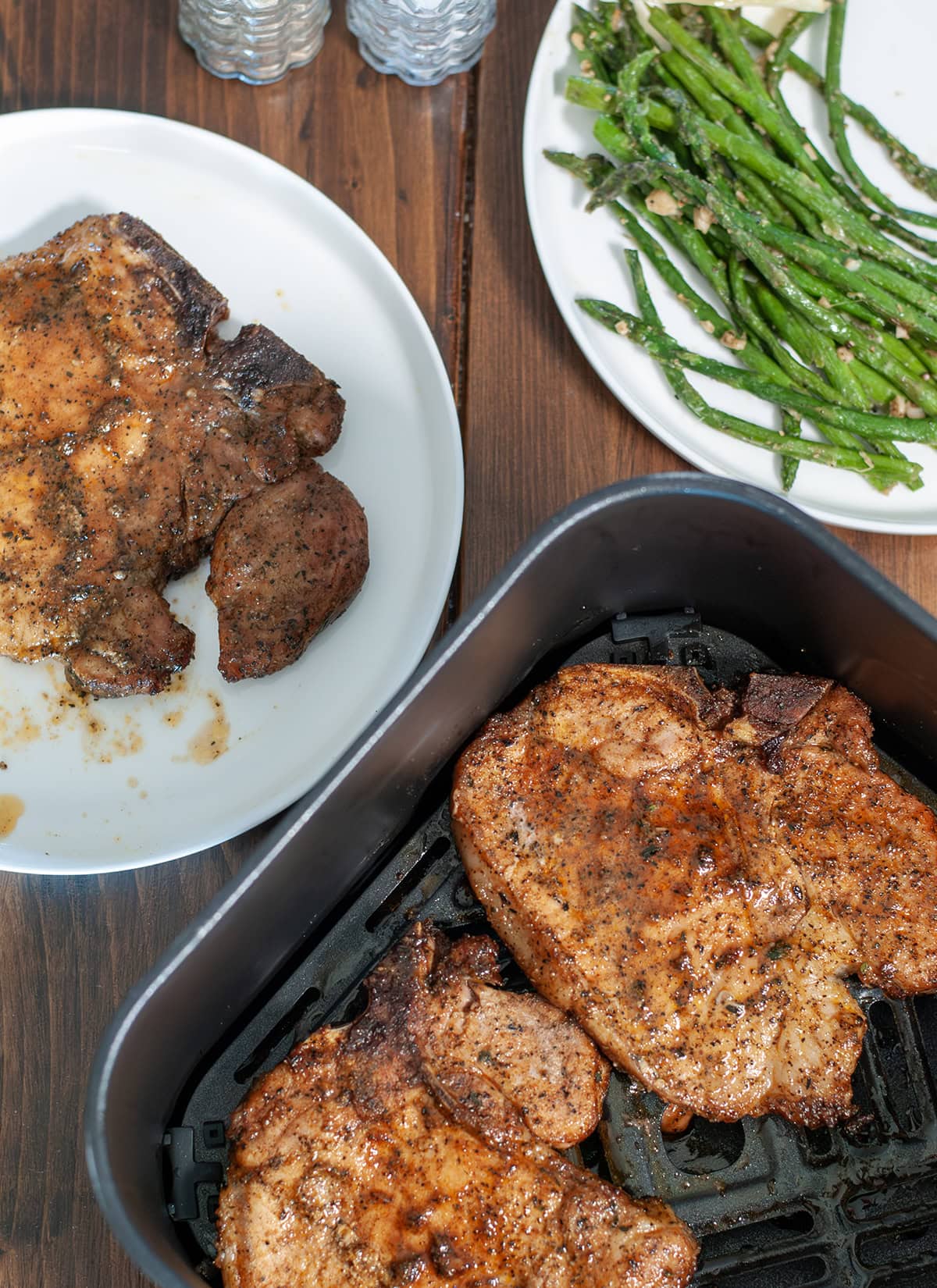 Crispy browned pork chops prepared in an air fryer and ready to eat. 