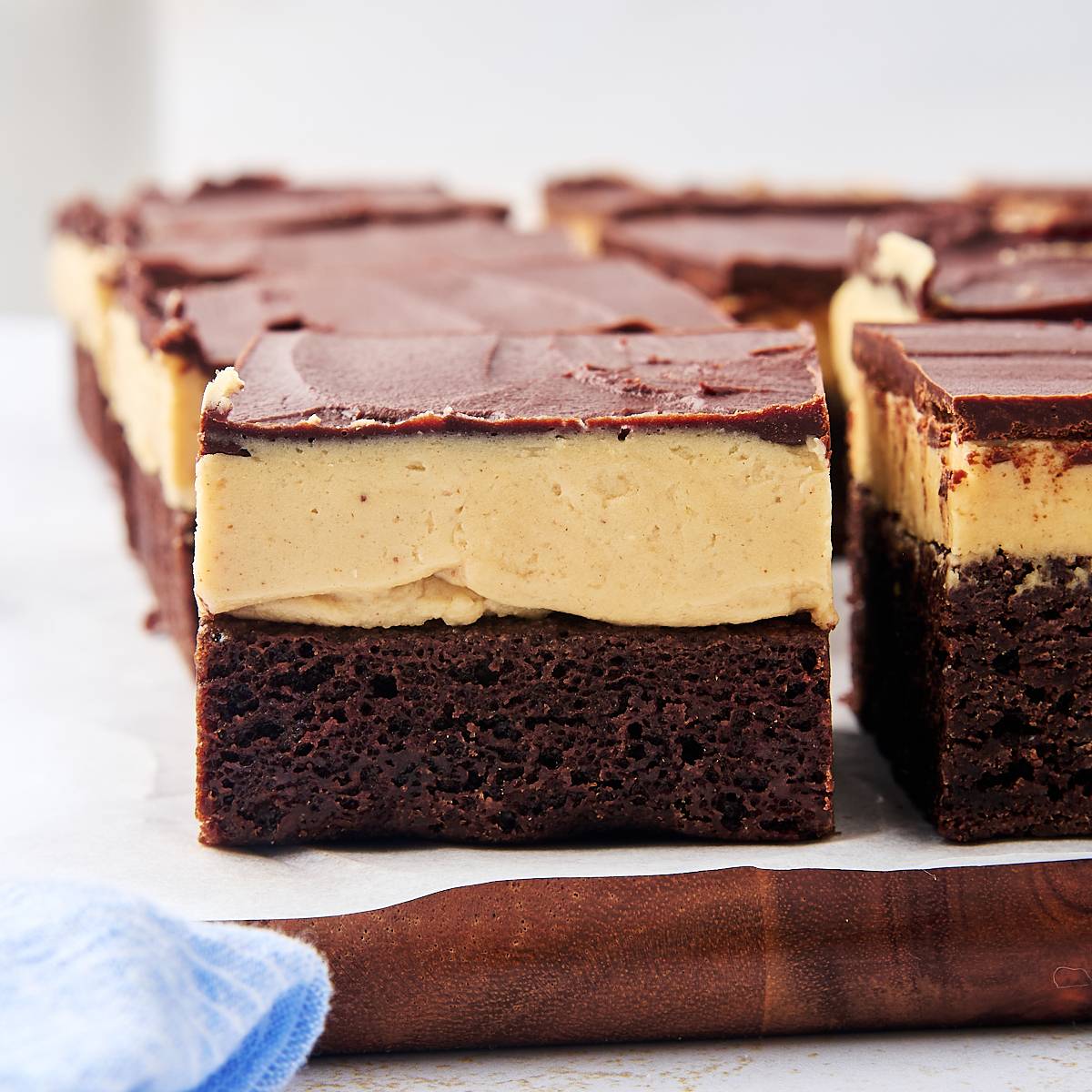 thick brownies topped with creamy peanut butter filling and chocolate ganache