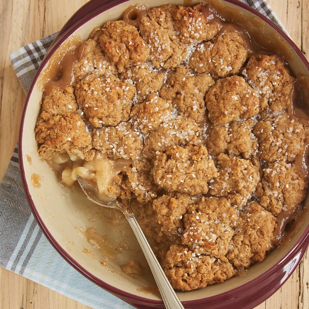spiced pear cobbler with biscuit topping in a round baking dish