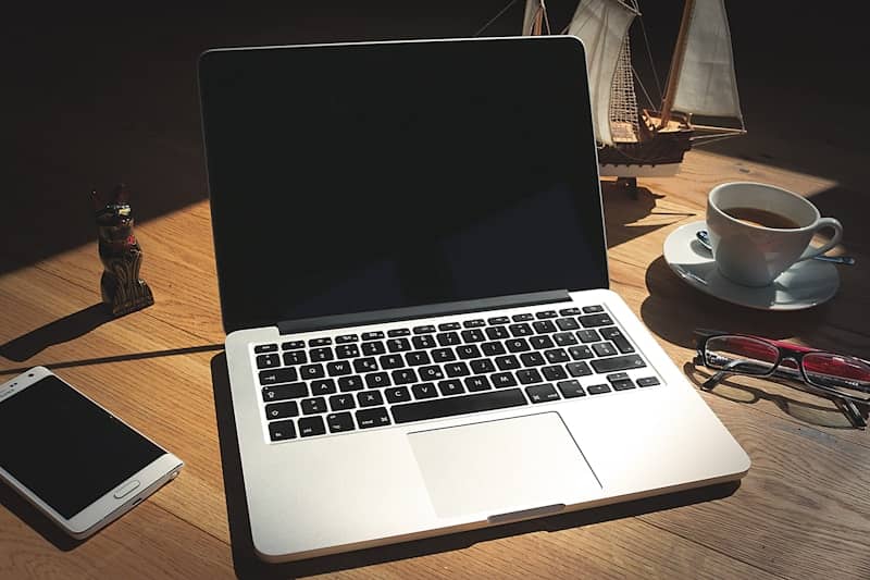 A laptop computer sitting on top of a wooden desk