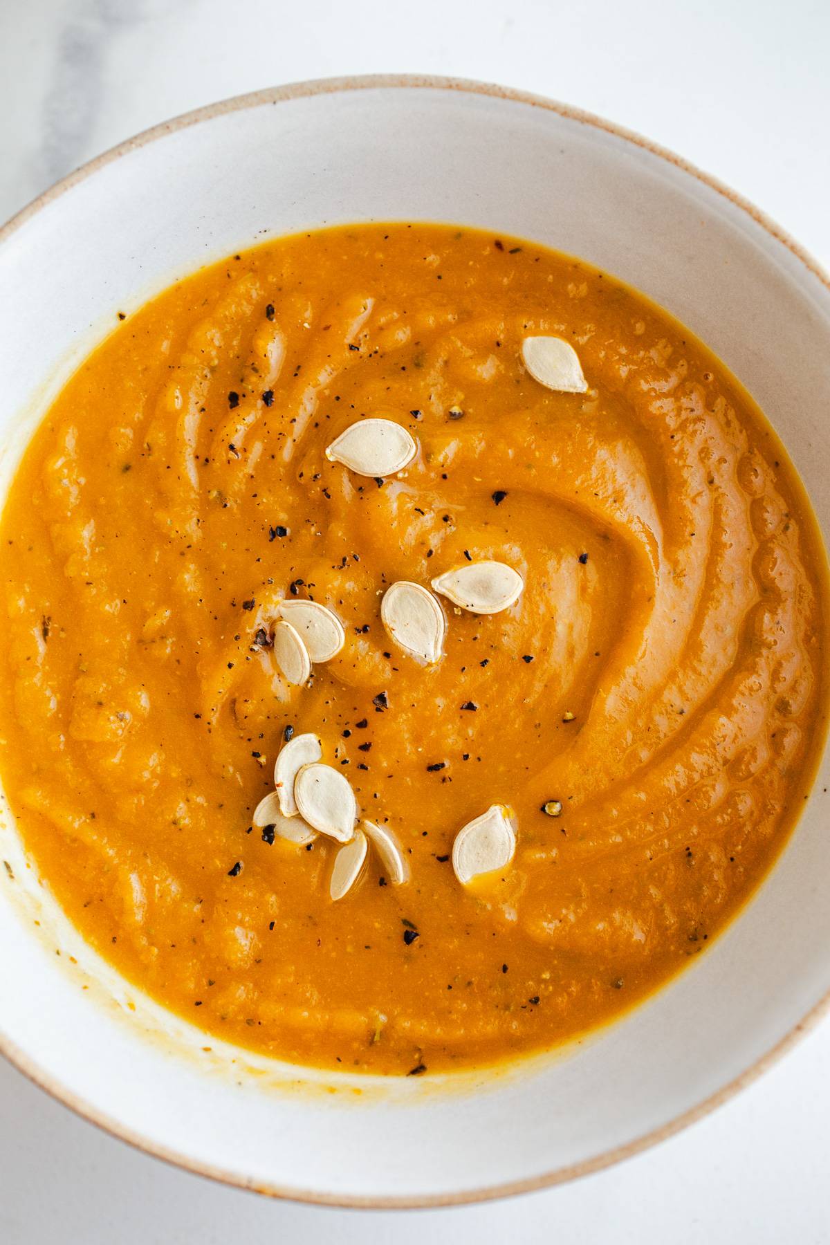 Acorn squash pumpkin soup in a white bowl.