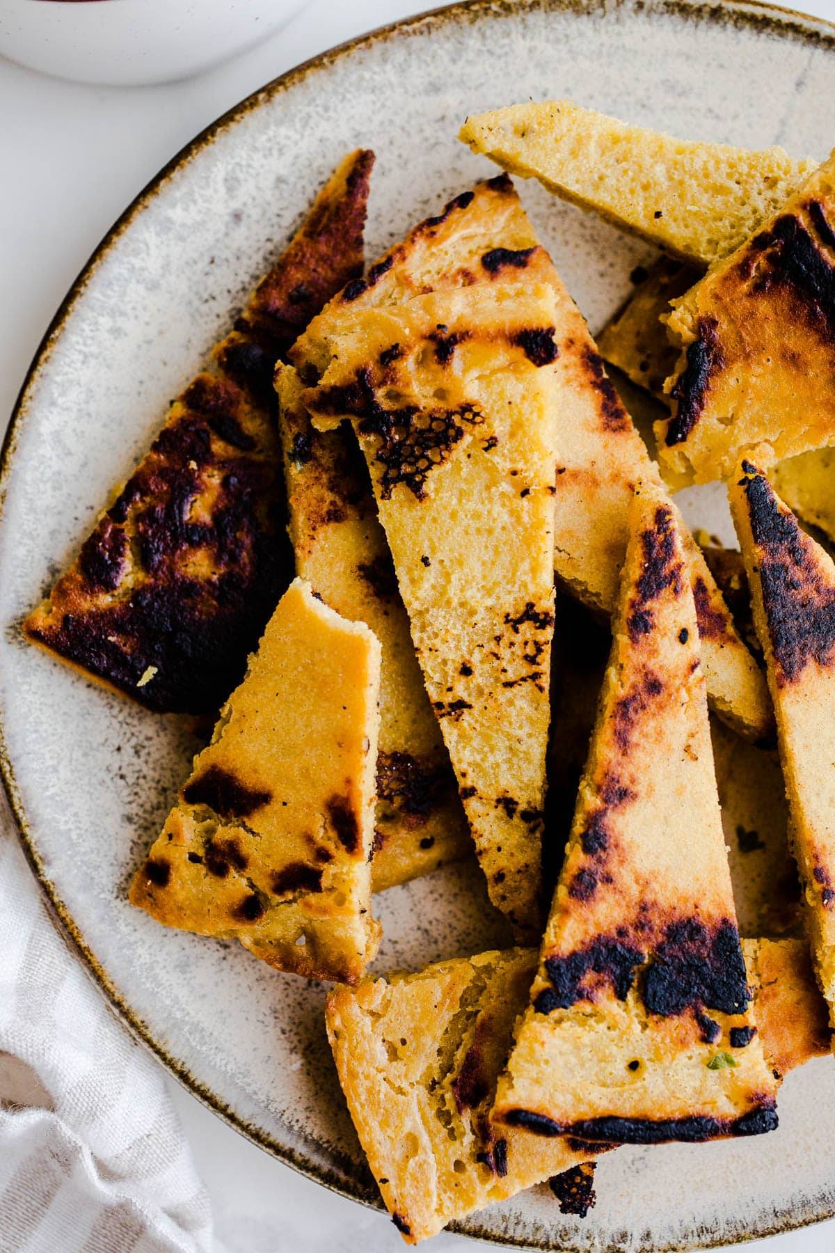 Socca chips on a white plate.