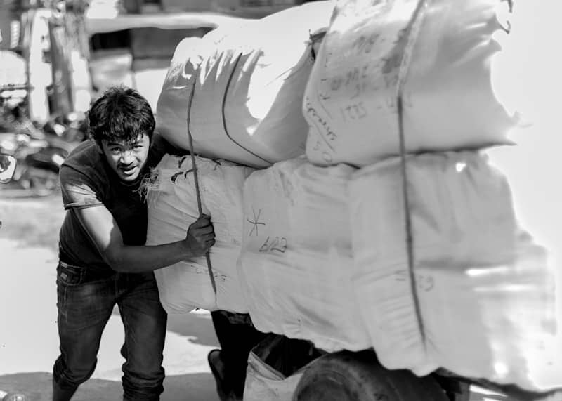 Man pushing a cart loaded with large sacks