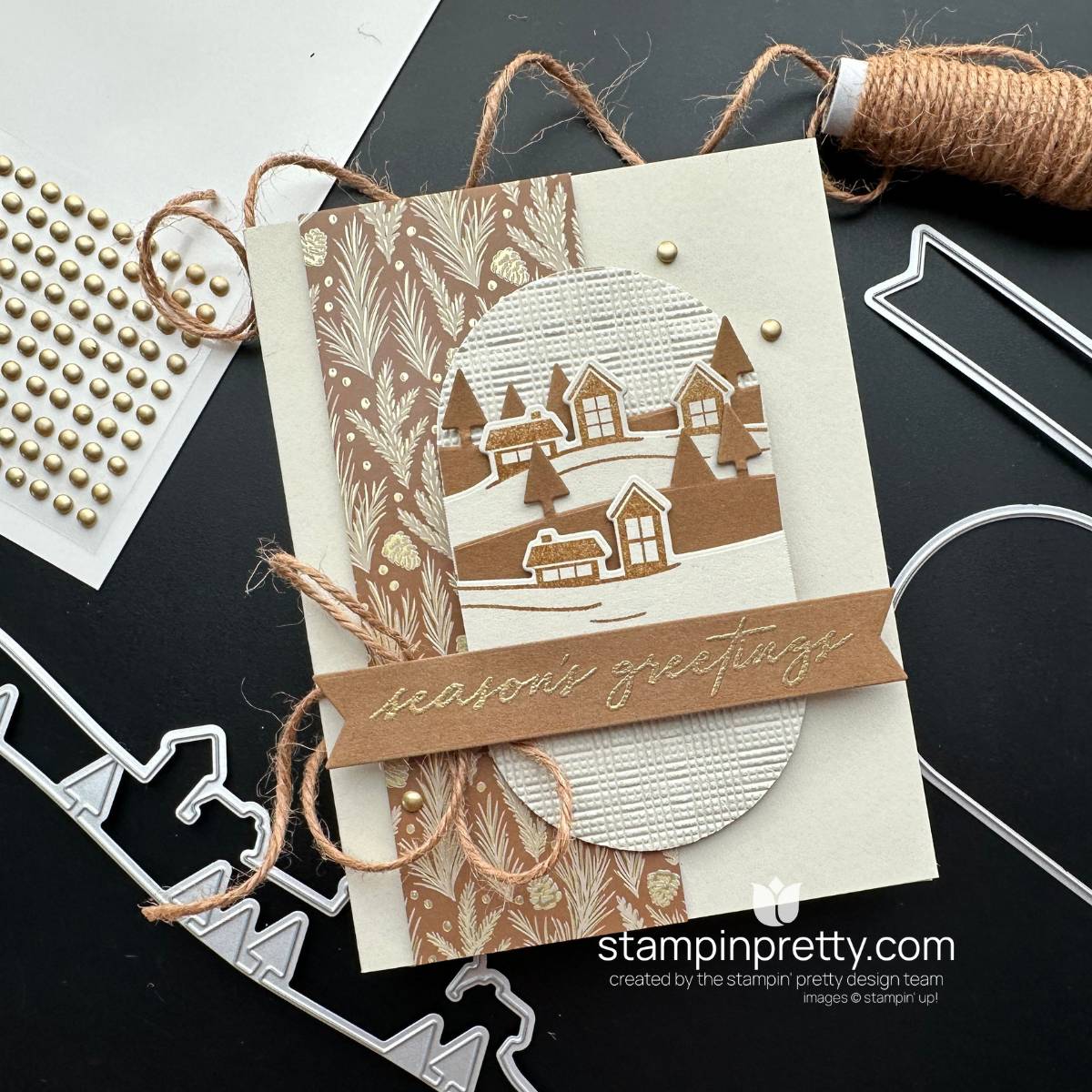 Neutral Noel Christmas card featuring a snowy layered village, textured circle, gold pine-patterned paper, natural trim and gold season’s greetings sentiment.